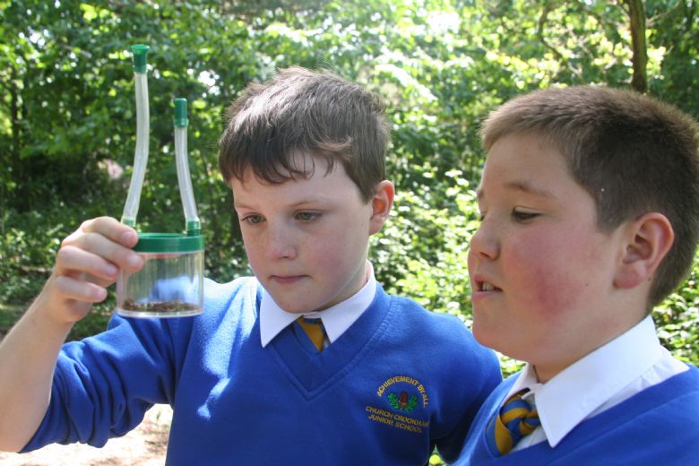  Two children in the wildlife garden using a pooter