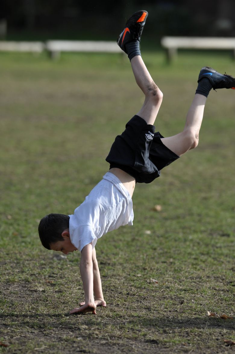  A young child doing a handstand on the school field