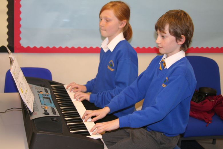  2 children playing the keyboard